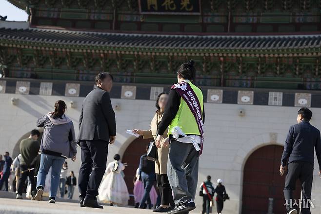 박평화씨가 인터뷰 도중 서울 광화문 앞에서 시민들에게 길을 안내하고 있다. ⓒ시사IN 이명익