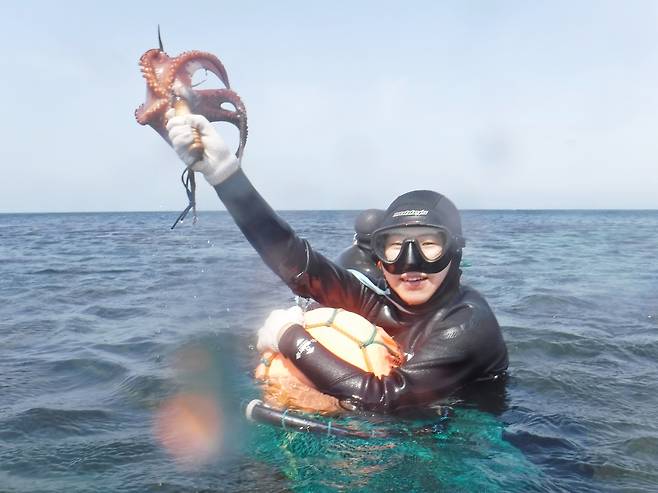 문어를 낚은 후 기뻐하는 관광객