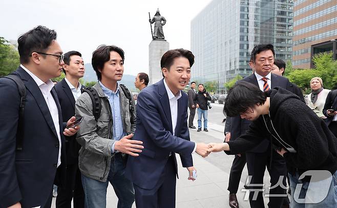 이준석 개혁신당 대통령 후보가 19일 오전 서울 종로구 광화문광장 이순신 동상 앞에서 기자회견을 마친 후 이동하며 시민과 인사하고 있다. 2025.5.19/뉴스1 ⓒ News1 김성진 기자