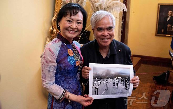 '네이팜탄 소녀'로 알려진 베트남 전쟁 생존자 판 티 킴 푹이 자신의 사진을 찍은 것으로 알려진 전 AP통신 사진 기자 닉 웃과 2023년 4월12일 코스타리카 산호세에 있는 외교부에서 함께 사진을 들고 있다.  닉 웃은 1972년 퓰리처상과 국제보도사진상을 수상했다. 하지만 국제보도사진재단은 2025년 5월 16일 이 사진을 누가 찍은 것인지에 대한 의혹이 제기됐다면서 닉 웃의 이름을 삭제했다고 밝혔다. ⓒ AFP=뉴스1 ⓒ News1 권영미 기자