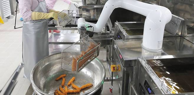 지난 2월 광주 송원고등학교에서 열린 '급식 로봇 기증식 및 시연회'에서 협동로봇 전문 기업 뉴로메카의 'INDY' 모델이 튀김 요리를 시연하고 있다./김영근 기자