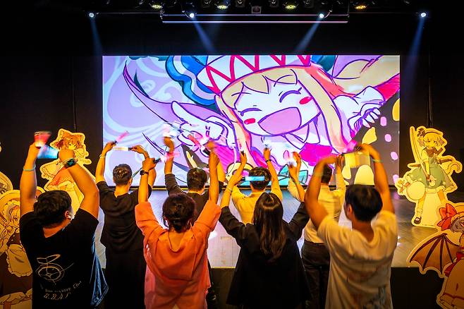 지난 14일 현대백화점 신촌점 12층 서브컬처 전문관에서 게임 캐릭터가 나오는 뮤직비디오 영상을 보는 사람들. 서점이었던 이 곳은 애니메이션과 게임 등 서브컬처 공연과 코스튬 플레이를 하는 공간으로 문 열 예정이다. /이신영 영상미디어 기자