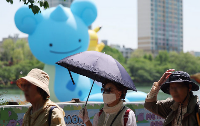 시민들이 모자와 양산을 쓰고 걸어가고 있다.ⓒ뉴시스