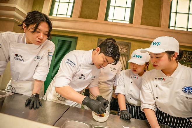 Chef Jang Miel (second from left) prepares his momguk ceam sauce, octopus confit and langoustine dish at the 10th Jeju Food & Wine Festival’s "Gourmet Dinner" held at Jeju Shinhwa World in Seogwipo, Jeju Island, Friday. (Jeju Food & Wine Festival)
