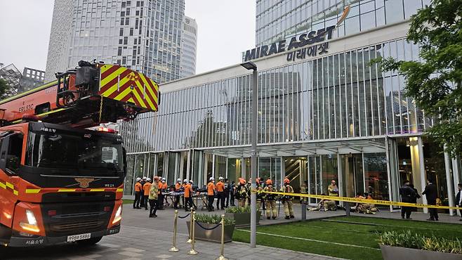 서울 중구 미래에셋센터원빌딩에서 불이 나 소방대원들이 진입 계획을 세우고 있다.