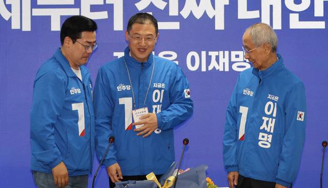 19일 서울 더불어민주당 여의도 당사에서 열린 중앙선거대책위원회에서 국민의힘을 탈당한 뒤 민주당에 입당한 김상욱 의원이 박찬대 대표 직무대행 겸 원내대표로부터 선거사무원 표찰을 받고 있다.  연합뉴스