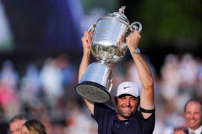 스코티 셰플러가 19일(한국시간) 시즌 두번째 메이저대회인 PGA 챔피언십에서 정상에 오른 뒤 우승컵 워너메이커 트로피를 번쩍 들어 올리고 있다.   [AFP]