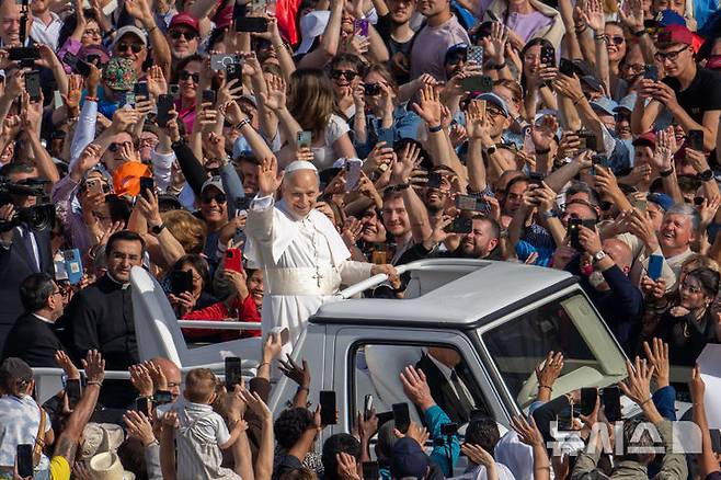 [바티칸=AP/뉴시스] 교황 레오 14세가 18일(현지 시간) 바티칸 성 베드로 광장에서 열린 즉위 미사에 무개차를 타고 이동하고 있다. 2025.05.19.