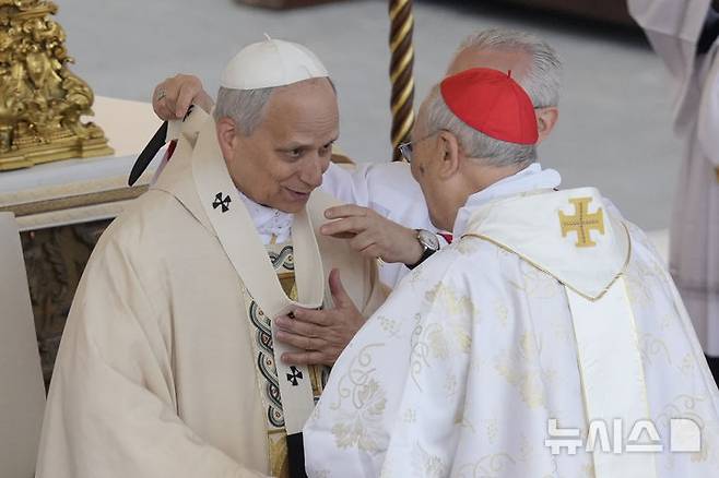 <font style="vertical-align: inherit;"><font style="vertical-align: inherit;">[바티칸=AP/뉴시스] 교황 레오 14세가 18일(현지 시간) 바티칸 성 베드로 광장에서 열린 즉위 미사에서 마리오 제나리 추기경으로부터 팔리움을 전달받고 있다. 2025.05.19.</font></font>