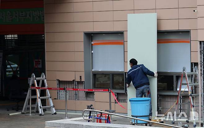 [서울=뉴시스] 이영환 기자 = 20일 오전 서울 마포구 서울서부지방법원에서 공사 관계자들이 파손된 외벽에 보수작업을 하고 있다.지난 19일 새벽 윤석열 대통령의 구속영장 발부에 지지자들이 집단 폭력 및 법원 안으로 침입하는 사고가 발생했다. 한편 서울서부지방법원은 법원은 정상적으로 운영될 것이라고 밝혔다. 다만 차량을 통한 출입은 불가능하고 출입자는 신분 확인이 필요하다고 전했다.  2025.01.20. 20hwan@newsis.com