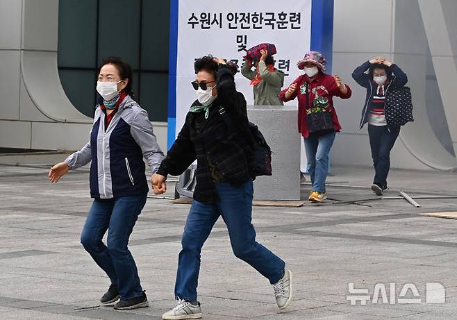 [수원=뉴시스] 김종택 기자 = 19일 경기 수원시 SK아트리움에서 열린 재난대응 안전한국훈련에서 시민들이 지진대피훈련을 하고 있다. 2025.05.19. jtk@newsis.com