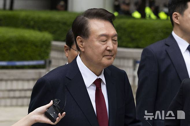 [서울=뉴시스] 사진공동취재단 = 윤석열 전 대통령이 19일 서울 서초구 중앙지방법원에서 열린 내란 우두머리 혐의, 직권남용 권리행사방해 혐의 사건 4차 공판의 오전 재판을 마친 뒤 이동하며 취재진 질문을 듣고 있다. 2025.05.19. photo@newsis.com