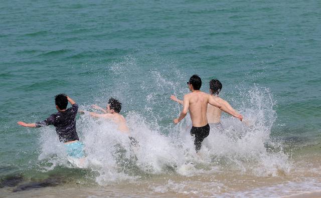 ▲ 30도를 넘는 무더위가 찾아온 20일 강원 강릉시 경포해변을 찾은 관광객들이 시원한 바다에 뛰어들고 있다. /연합뉴스 제공