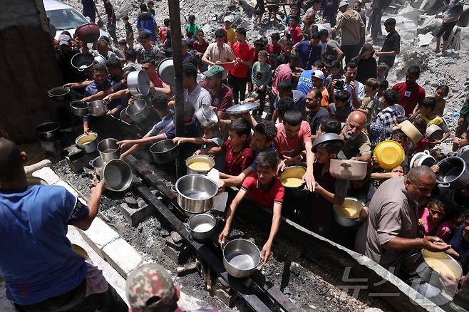 19일(현지시간) 팔레스타인 가자지구 북부 자발리아에서 난민들이 음식 배급을 위해 모여있다. ⓒ AFP=뉴스1
