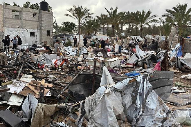 팔레스타인 시민들이 18일(현지시간) 가자지구 마와시 지역 난민 텐트 캠프 이스라엘 공격 현장을 점검하고 있다 ⓒ AFP=뉴스1