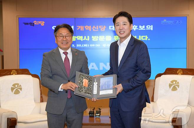 강기정 광주시장이 20일 오전 시청 비즈니스룸에서 광주를 찾은 이준석 개혁신당 대선 후보에게 한강 작가의 소설 '소년이 온다'를 전달한 후 기념촬영을 하고 있다.(광주시 제공. 재판매 및 DB 금지) 2025.5.20/뉴스1 ⓒ News1 박준배 기자