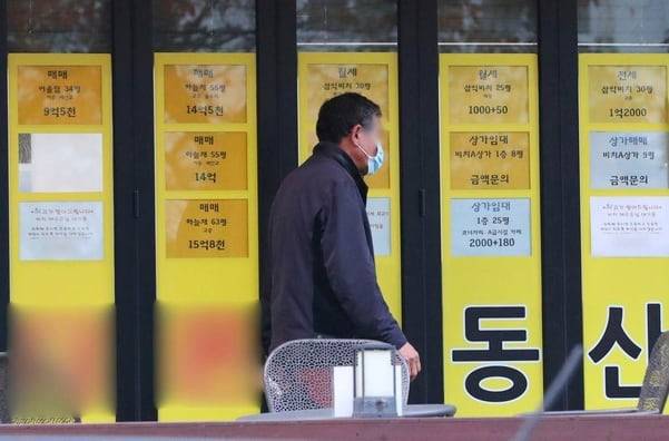 지난 달 12일 부산 수영구 남천동 삼익비치 아파트 근처 부동산을 한 시민이 지나가고 있다.