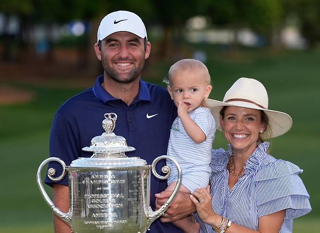 남자 골프 세계랭킹 1위 스코티 셰플러(왼쪽)가 19일 미국프로골프(PGA)투어 메이저대회 PGA챔피언십을 제패한 뒤 아내 메러디스, 아들 베넷과 함께 우승컵을 앞에 두고 기뻐하고 있다. 샬럿=AP 뉴시스