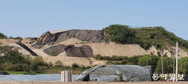 인천 서구 백석동 수도권매립지 인근에 있는 사월마을. 비닐 하우스 뒤편으로 순환골재 적치장이 보인다. 인천시 제공