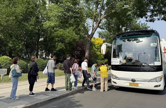 20일 중국 톈진의 한 거리에서 베이징에 있는 재외 투표소로 가는 셔틀버스에 유권자들이 줄을 서 탑승하고 있다. 베이징/이정연 특파원