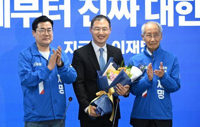 국민의힘을 탈당한 뒤 더불어민주당에 입당한 김상욱(가운데) 의원이 19일 서울 여의도 민주당 중앙당사에서 열린 입당식에 참석해 꽃다발을 받은 뒤 환하게 웃고 있다. 고영권 기자