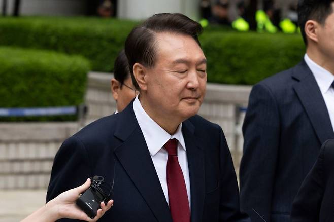 윤석열 전 대통령이 19일 서울 서초구 서울중앙지방법원에서 열린 내란 우두머리 혐의, 직권남용 권리행사방해 혐의 사건 4차 오전 공판을 마친 후 취재진의 질문을 받으며 이동하고 있다. 사진공동취재단 &nbsp;