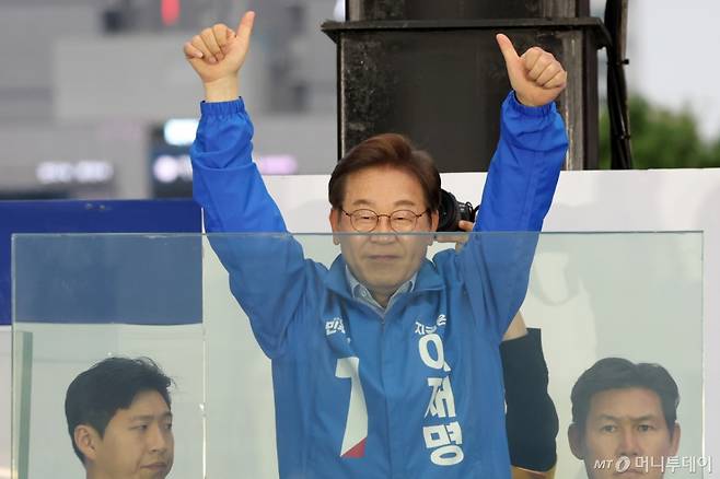 이재명 더불어민주당 대선후보가 20일 경기 김포시 구래역 문화의 거리에서 열린 유세에서 방탄 유리막 연단에서 사다리에 올라 시민들에게 인사하고 있다. /사진=뉴시스 제공.