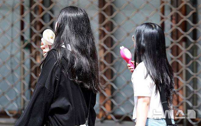[대구=뉴시스] 이무열 기자 = 대구 낮 최고기온이 28도까지 오르며 초여름 날씨를 보인 19일 대구 중구 동성로에서 시민들이 손 선풍기를 들고 길을 걷고 있다. 2025.05.19. lmy@newsis.com
