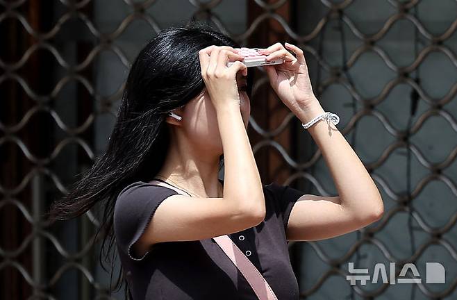 [대구=뉴시스] 이무열 기자 = 대구 낮 최고기온이 28도까지 오르며 초여름 날씨를 보인 19일 대구 중구 동성로에서 한 시민이 휴대폰으로 햇빛을 가린 채 길을 걷고 있다. 2025.05.19. lmy@newsis.com