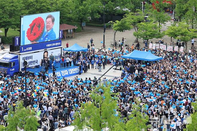 [고양=뉴시스] 조성우 기자 = 이재명 더불어민주당 대선후보가 20일 경기 고양시 일산동구 일산문화광장 앞에서 열린 집중유세에서 장미로 만든 투표기호 화환을 선물받고 있다. (공동취재) 2025.05.20. photo@newsis.com