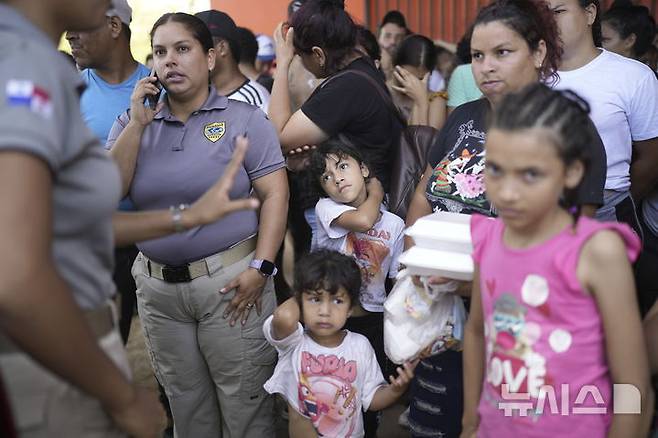 [팔렌케=AP/뉴시스] 2월 26일(현지 시간) 파나마 팔렌케의 한 보호소에서 이주민들이 파나마 이민 당국 관계자들로부터 음식을 받고 있다. 도널드 트럼프 미국 대통령의 이민 정책 강화로 미국행을 포기하고 멕시코 남부에서 되돌아온 이들은 본국으로 돌아갈 준비를 하고 있다. 2025.02.27.