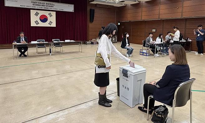 제21대 대통령 선거 재외투표 첫날인&nbsp;20일 주일본 한국대사관 영사부가 있는 도쿄 미나토구 민단 중앙회관에 마련된 재외투표소에서 유권자가 투표함에 투표용지를 넣고 있다. 도쿄=연합뉴스