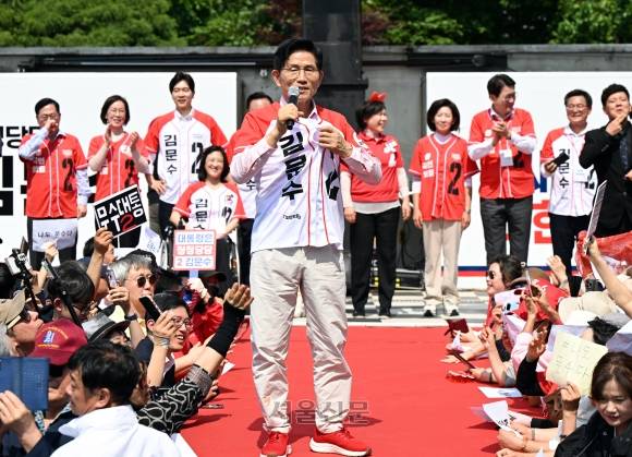 김문수 국민의힘 대선후보가 20일 서울 서초구 고속터미널 광장 유세에서 방탄조끼를 안 입었다고 이야기하며 옷을 잡고 있다. 2025.5.20 안주영 전문기자