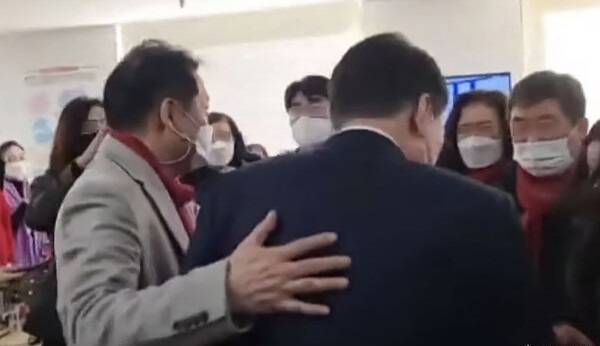 2022년 1월1일 건진법사 전성배씨가 윤석열 당시 국민의힘 대선후보 등에 손을 얹고 있다. ⓒ유튜브 갈무리