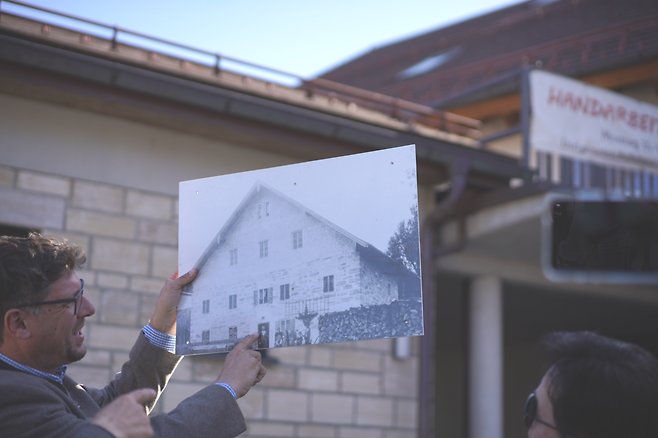 독일 후글핑 마을의 선출직 면장(뷔어거마이스터)인 마르쿠스 후버가 지난 4월 7일(현지시간) 마을의 한 건물에 대해 설명하면서, 100년 전에 찍은 건물 사진을 보여주고 있다. 이 마을은 건물을 고쳐 쓰거나 허물고 새로 지을 때도 최대한 예전 모습을 유지토록 한다. 진정은씨 제공.