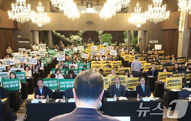 21일 오후 서울 용산구 피스앤파크컨벤션에서 열린 간호법 제정에 따른 진료지원업무 제도화 방안 공청회에서 대한간호협회 회원들과 공공운수노조 의료연대본부 조합원들이 박민수 보건복지부 2차관의 인사말이 진행되는 동안 항의 피켓을 들고 있다. 2025.5.21/뉴스1 ⓒ News1 오대일 기자