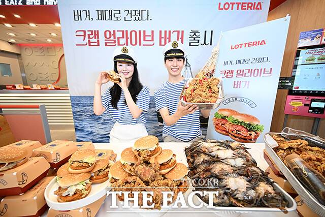 롯데GRS의 버거 프랜차이즈 롯데리아가 21일 오전 서울 중구 롯데리아 동대문역사문화공원역점에서 신메뉴 '크랩 얼라이브 버거' 출시 기념 행사를 진행한 가운데 모델들이 포즈를 취하고 있다. /서예원 기자