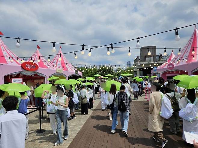 21일 오전 11시경 '메이크업존' 앞 모습. 초록색 우산을 든 참가자들로 가득하다. 사진=박재현 기자