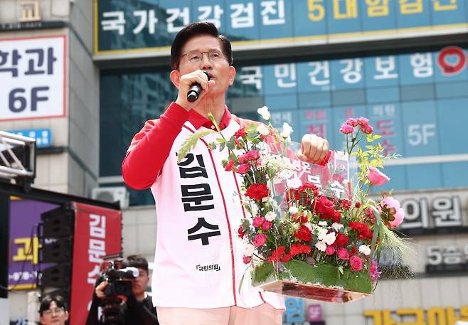 국민의힘 김문수 대선 후보가 21일 경기 고양시 덕양구 화정역 문화광장 앞에서 열린 집중유세에서 꽃바구니들 들어 보이고 있다. [공동취재] 연합뉴스