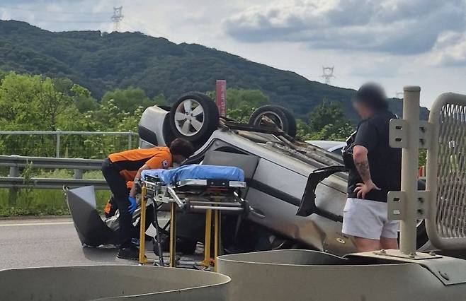 21일 오후 경기 양평군 양서면 신원역 인근 6번 국도에서 차량이 전복돼 소방대원이 구조 작업을 벌이고 있다. 독자 제공