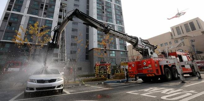 지난해 11월 20일 전주시 덕진구 팔복LH아파트 및 더 메이호텔에서 행정안전부를 비롯한 전북소방본부, LH 등 유관기관이 참여한 합동 전기차 화재 대응 제4차 READY Korea 훈련에서 소방대원들이 EV-드릴랜스(관통형 배터리 직접 주수장치) 장비를 사용하여 전기차 화재를 진압하고 있다. 뉴스1