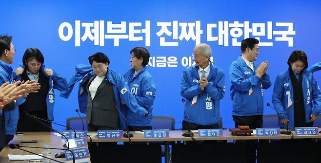 지난 14일 서울 여의도 더불어민주당사에서 열린 중앙선거대책위원회의에서 기본소득당 용혜인 의원(왼쪽), 조국혁신당 김선민 당대표 권한대행(왼쪽 두번째), 진보당 김재연 상임대표(오른쪽)가 민주당 점퍼를 입고 있다. 연합뉴스