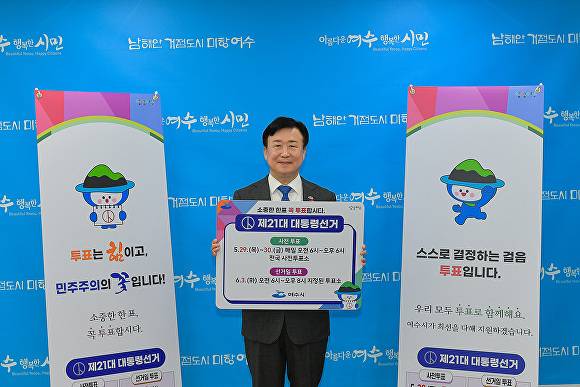 정기명 여수시장이 지난 20일 투표 참여 관련 팻말을 들고 홍보를 하고 있다.  [사진=여수시]