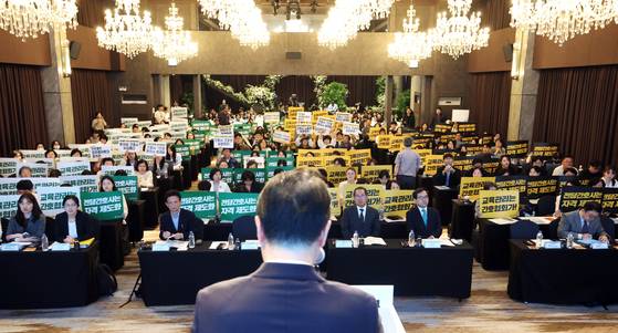 21일 오후 서울 용산구 피스앤파크컨벤션에서 열린 간호법 제정에 따른 진료지원업무 제도화 방안 공청회에서 대한간호협회 회원들과 공공운수노조 의료연대본부 조합원들이 박민수 보건복지부 2차관의 인사말이 진행되는 동안 항의 피켓을 들고 있다. 뉴스1