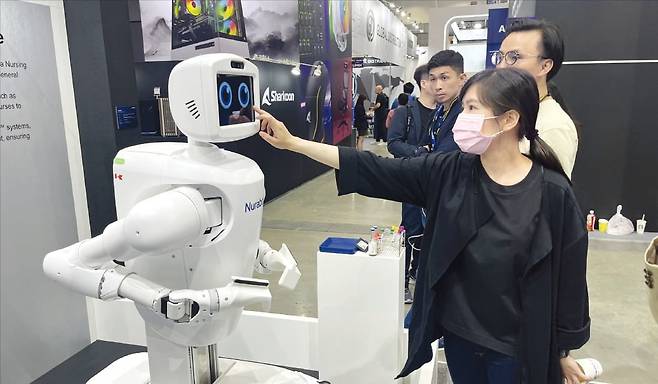 < 관람객과 만난 폭스콘 간호로봇 > 20일 대만 타이베이 난강전시장에서 열린 ‘컴퓨텍스 2025’에서 관람객이 대만 폭스콘과 일본 가와사키가 공동 개발한 인공지능(AI) 간호로봇을 살펴보고 있다.  박의명 기자