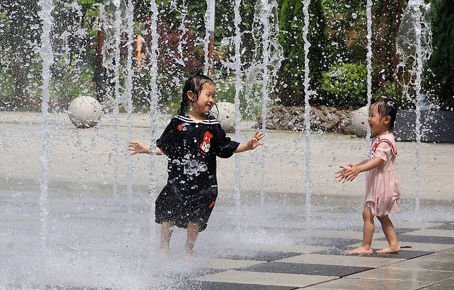 덥고 습한 공기 유입으로 찜통더위가 찾아온 21일 서울 성동구 서울숲에서 어린이들이 분수 물줄기에 즐거워하고 있다. 연합뉴스