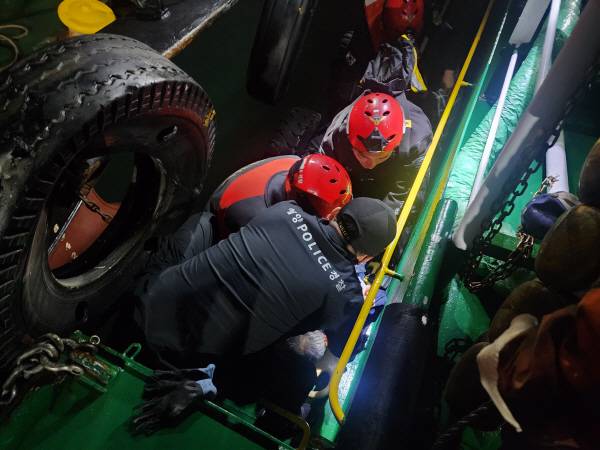 지난 20일 밤 부산항 5부두에서 급유선 사이에 끼이는 사고를 당한 항해사를 해양경찰이 구조하고 있다. 부산해양경찰서 제공