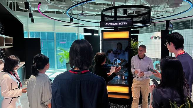 A TikTok official explains how moderation of harmful content is conducted at the Transparency and Accountability Center in Singapore, May 13. (TikTok)