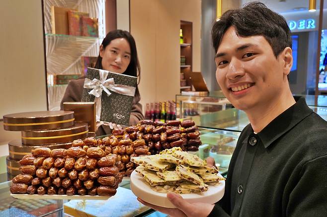 People hold Bateel's chocolates at its store in Lotte World Mall in Jamsil, southern Seoul, which opened in November 2024. [YONHAP]