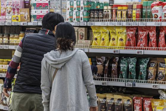 Shoppers inspect instant coffee mixes displayed at a discount mart in southern Seoul on April 2. [YONHAP]